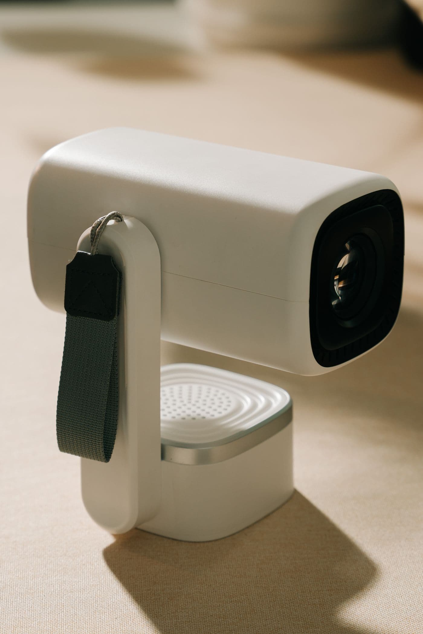 Mini projetor portátil branco com lente frontal e pega